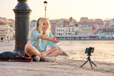 Genç bayan blogcu video içeriğini kaydediyor, akıllı telefon kullanarak takipçilerle konuşuyor