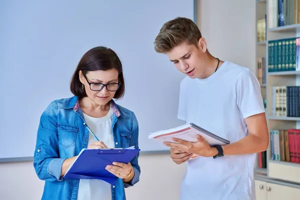 Collège étudiant gars adolescent réunion discuter avec professeur mentor en classe — Photo