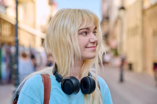 Portrait extérieur d'adolescente souriante heureuse, blonde avec écouteurs — Photo