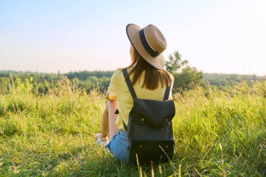 Arka plan, şapkalı kadın vahşi doğanın yaz manzarasının tadını çıkarıyor.