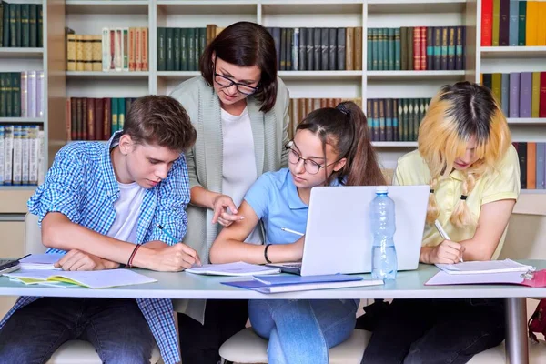 Leçon à la bibliothèque, professeur de lycée avec groupe d'adolescents — Photo