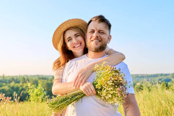 Счастливая влюбленная пара средних лет с букетом полевых цветов, — стоковое фото