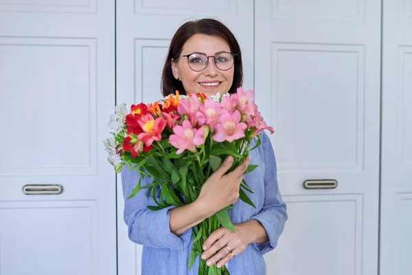 Retrato de una mujer sonriente de mediana edad con un ramo de flores —  Fotos de Stock