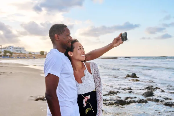 Pareja feliz enamorada tomando selfie juntos en el teléfono inteligente, en la playa — Foto de Stock