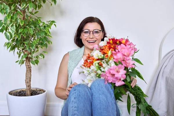 Retrato de una mujer feliz de mediana edad con un ramo de flores —  Fotos de Stock