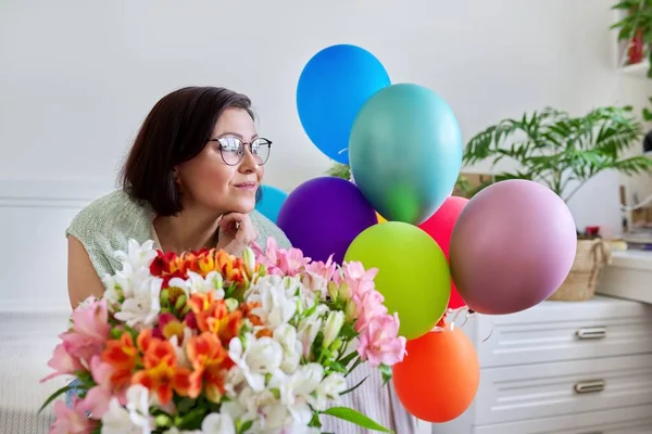 Retrato de mujer feliz de mediana edad con ramo de flores, globos —  Fotos de Stock