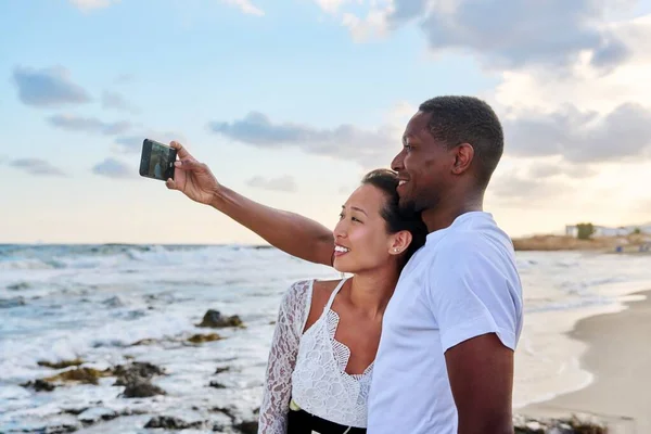 Boldog pár szerelmes csinál szelfi együtt okostelefon, a strandon — Stock Fotó