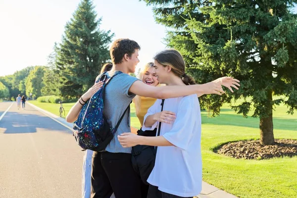 Encuentro de amigos adolescentes sonrientes en un soleado parque de verano — Foto de Stock