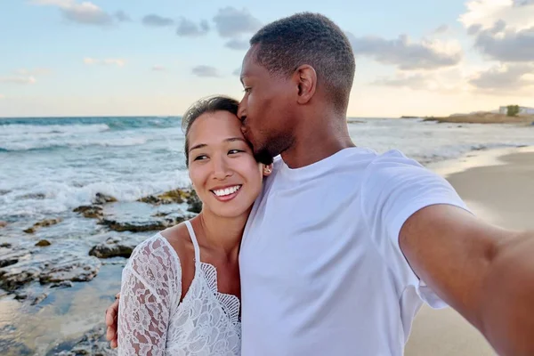 Ευτυχισμένο ζευγάρι ερωτευμένο να φιλιέται βγάζοντας selfie μαζί σε smartphone, στην παραλία — Φωτογραφία Αρχείου
