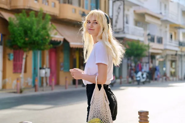 Ung tonåring blond promenader längs gatan av sommaren turist stad — Stockfoto