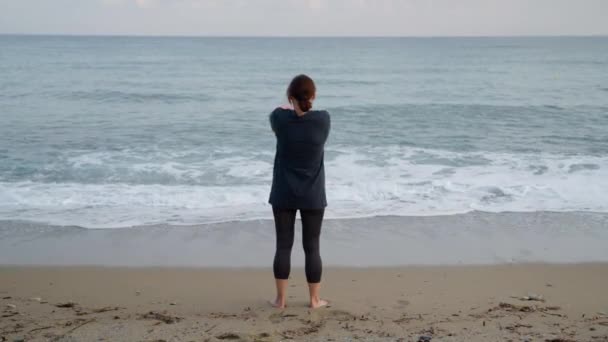 Ώριμη γυναίκα κάνει πρωινές ασκήσεις στην παραλία, πίσω όψη — Αρχείο Βίντεο