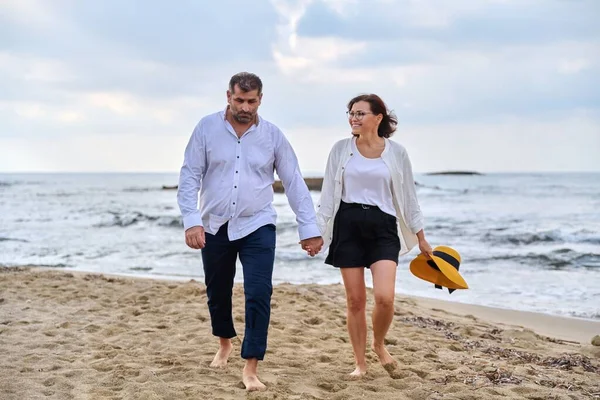 Boldog középkorú pár sétál együtt a parton. — Stock Fotó