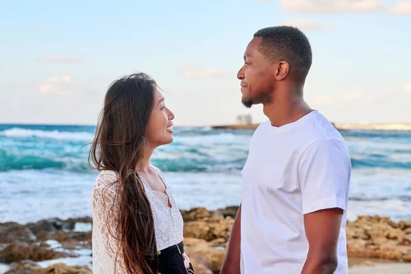 Joven hermosa pareja mirando a los ojos de perfil, en el paisaje marino —  Fotos de Stock