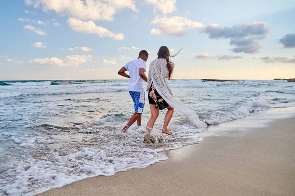 Gelukkig paar lopen samen op het strand op zomerdag, achteraanzicht — Stockfoto