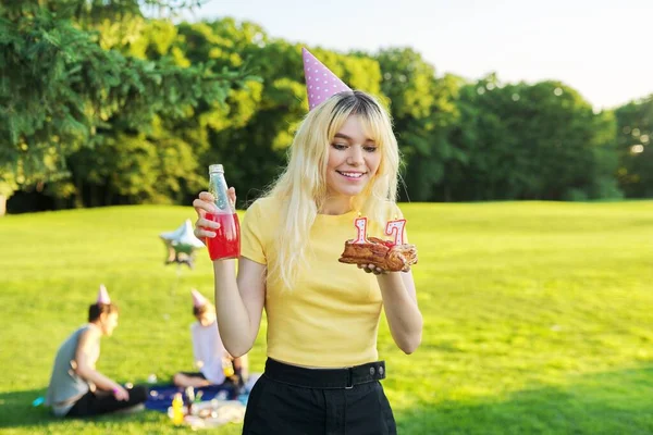 Mooi tiener meisje in een festiv hoed op haar verjaardag met een taart en kaarsen. — Stockfoto