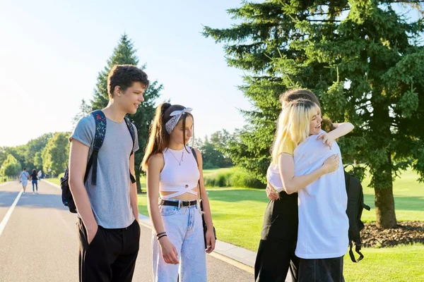 Möte med leende tonårsvänner i en solig sommarpark — Stockfoto