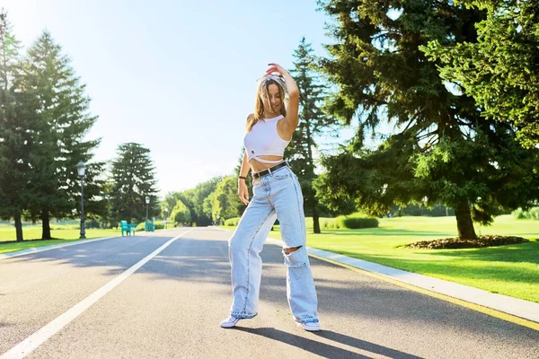 Táncoló fiatal tinédzser lány az úton a parkban — Stock Fotó