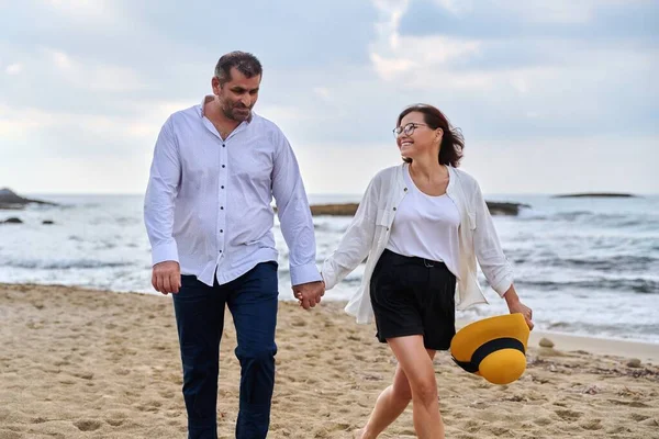 Feliz pareja de mediana edad caminando juntos en la playa. — Foto de Stock