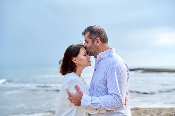 Mature happy loving couple kissing on the sea beach. — стоковое фото
