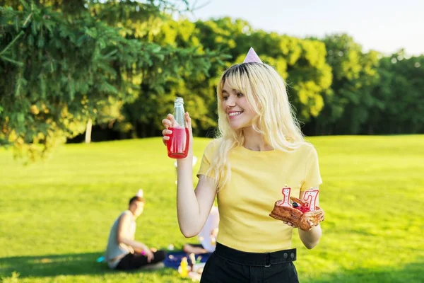 Schöne Teenager-Mädchen mit festlichem Hut an ihrem Geburtstag mit Kuchen und Kerzen. — Stockfoto