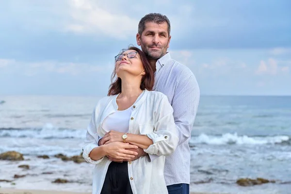 Retrato al aire libre de pareja adulta abrazándose en la orilla del mar —  Fotos de Stock