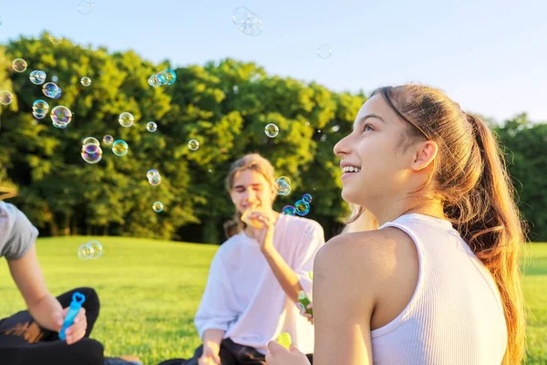 Šťastná dospívající dívka 13, 14 let foukání bubliny. — Stock fotografie