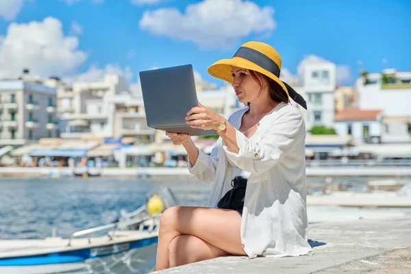 Retrato de la mujer en el sombrero con el ordenador portátil hablando en la comunicación de vídeo usando el ordenador portátil — Foto de Stock