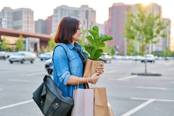 商场停车场中年妇女提购物袋的城市形象. — 图库照片