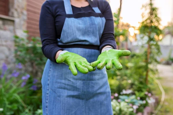 Gros plan de jardinier womans mains dans des gants de jardinage, fond de jardin de printemps. — Photo