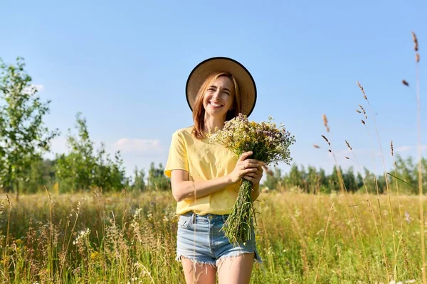 Letní portrét šťastné třicátnice s kyticí divokých květin — Stock fotografie