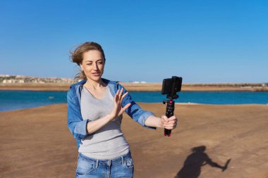 Olgun bir kadın akıllı telefondan video kaydediyor.