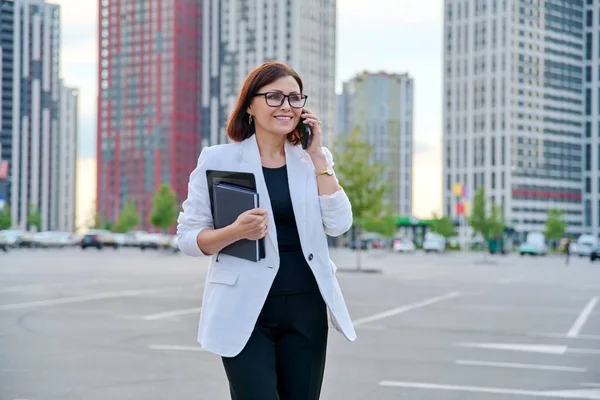 Портрет успешной зрелой предпринимательницы со смартфоном на открытом воздухе — стоковое фото
