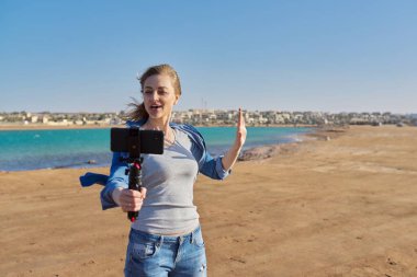 Olgun bir kadın akıllı telefondan video kaydediyor.