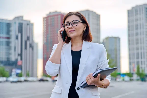 Retrato de empresária madura bem sucedida com smartphone ao ar livre — Fotografia de Stock