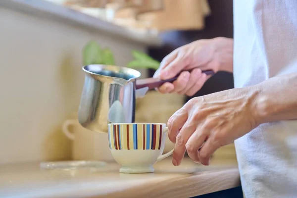 Zbliżenie kobiecych dłoni przygotowujących kawę w żelaznej cezwie. — Zdjęcie stockowe