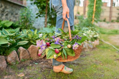 Bahar bahçesi çiçekli sepet kadının elinde.