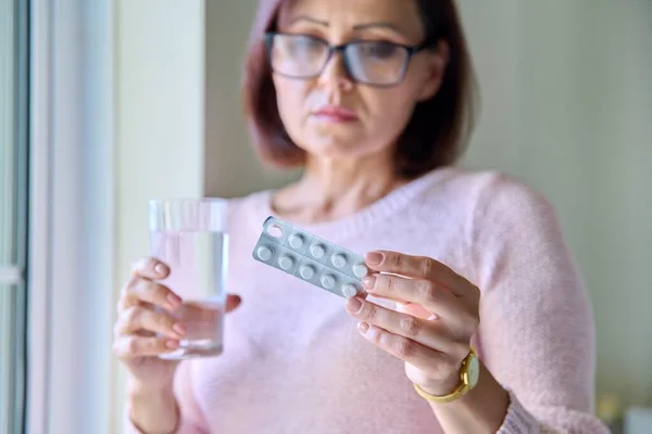 Érett, szomorú nő, tablettákkal és pohár vízzel otthon.. — Stock Fotó