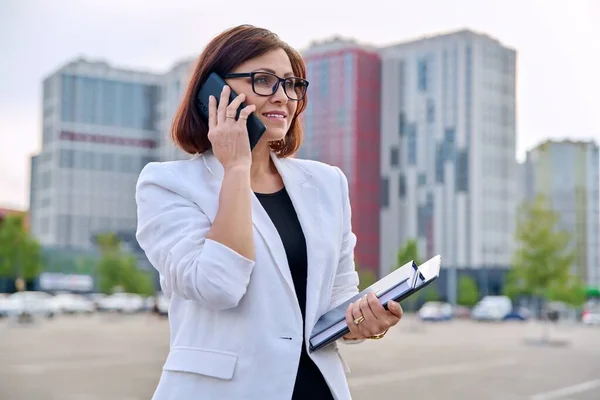 Портрет успешной зрелой предпринимательницы со смартфоном на открытом воздухе — стоковое фото