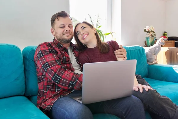 Feliz sorrindo casal de família de meia idade olhando para a tela do laptop juntos — Fotografia de Stock