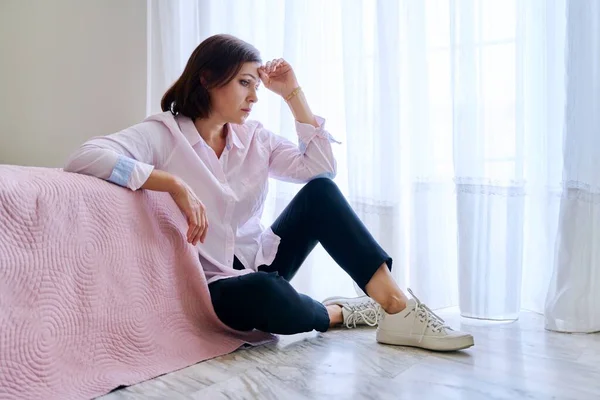 Szomorú középkorú depressziós nő ül a padlón a hálószobában.. — Stock Fotó