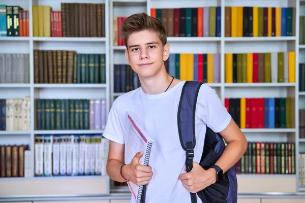 Retrato de adolescente do sexo masculino olhando para a câmera na biblioteca — Fotografia de Stock