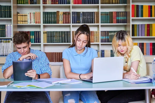 Grupo de estudiantes adolescentes que estudian en la biblioteca escolar. —  Fotos de Stock