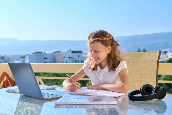 Ragazza bambino con le cuffie sta studiando utilizzando un computer portatile. — Foto Stock