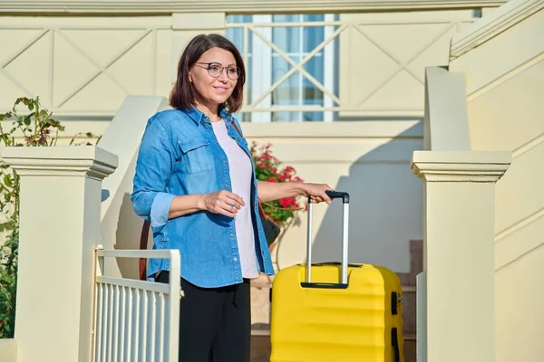 집안 현관 계단에 여행 가방을 든 중년의 여자 — 스톡 사진