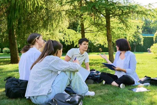 Grupo de estudiantes de secundaria con maestra, en el césped del campus — Foto de Stock