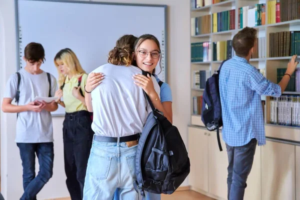 Skupina teenagerů kluci a dívky jsou vítáni, setkání, úsměv, radovat se uvnitř školy — Stock fotografie