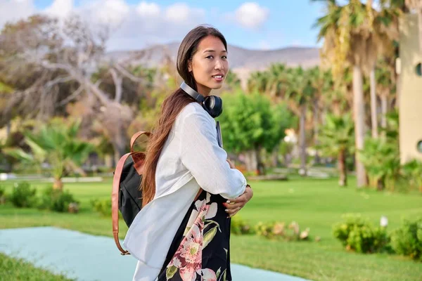 Εξωτερική πορτρέτο της ασιάτισσας φοιτήτρια με σακίδιο ακουστικά laptop κοιτάζοντας κάμερα — Φωτογραφία Αρχείου