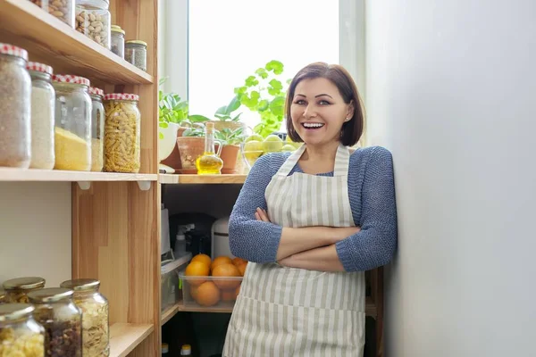 Портрет усміхненої жінки в фартусі на кухні в коморі — стокове фото