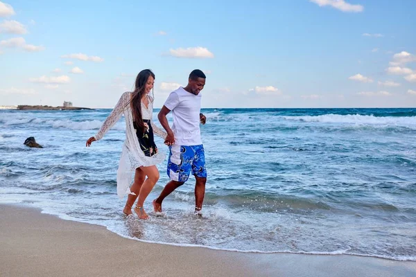 Jong gelukkig paar lopen op het strand hand in hand, kopiëren ruimte — Stockfoto