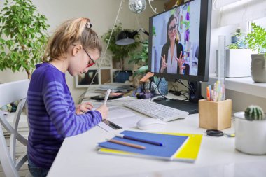 Bilgisayar dinleyerek evde oturan bir kız çocuğu.